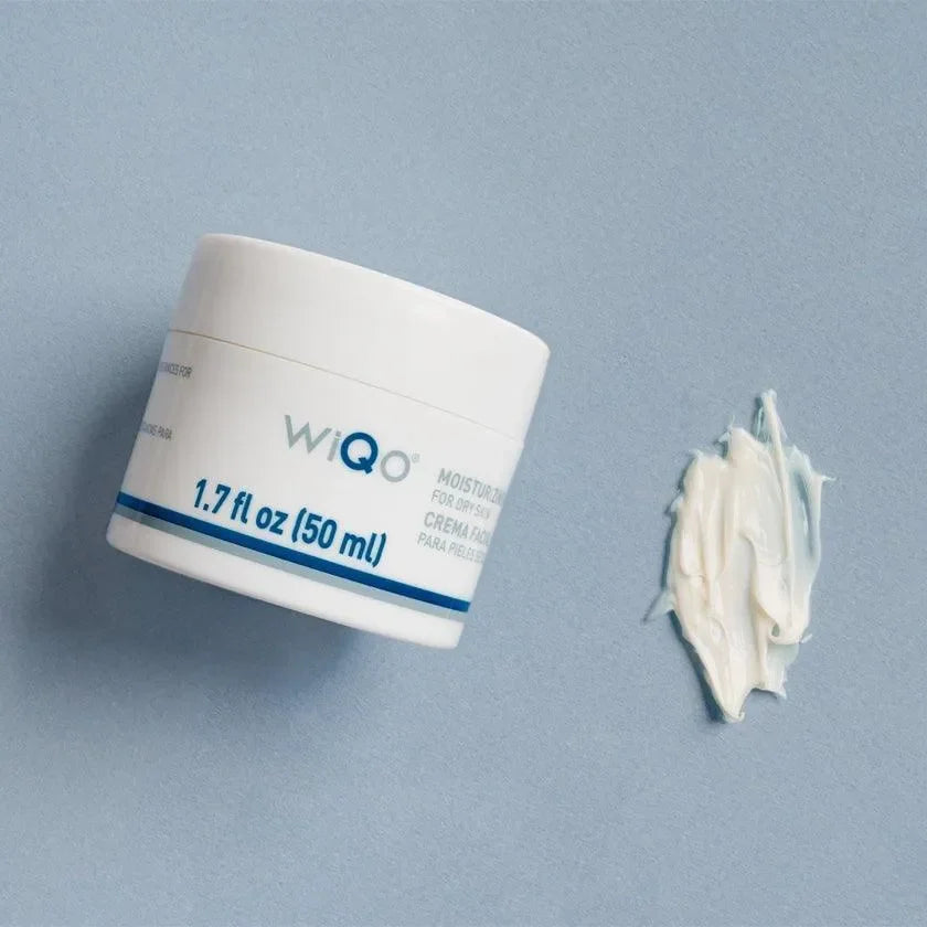 WiQo Moisturizing Face Cream For Dry Skin white jar on a blue background beside a smeared cream texture swatch.